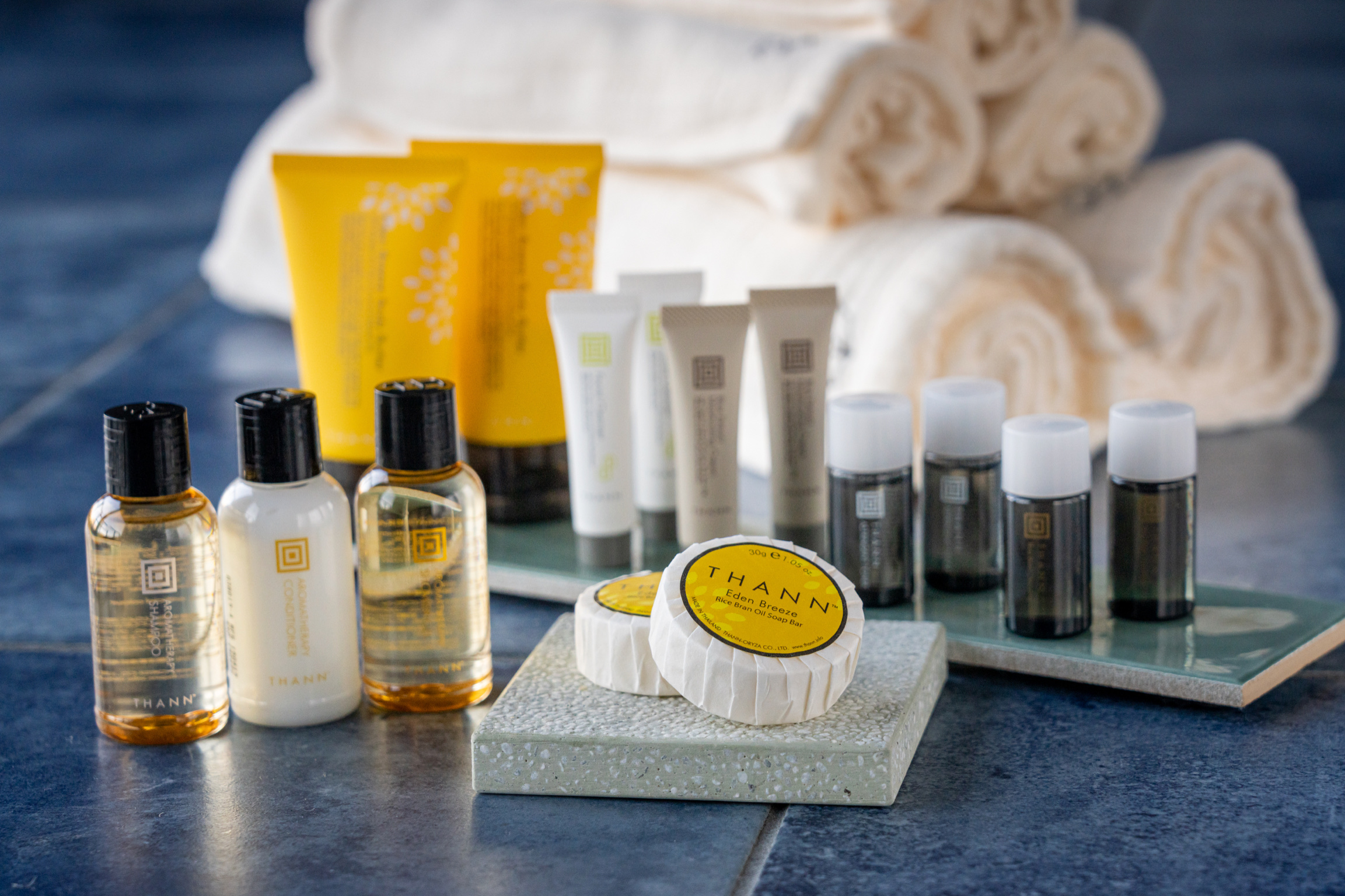 THANNアメニティと白いタオルが並ぶ洗面台の一角